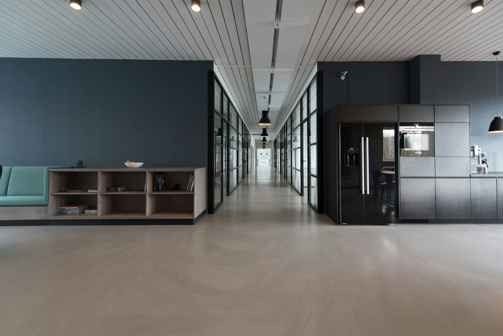 Empty UK-style commercial office interior with suspended ceiling grid, glazed partitions and workplace circulation space.